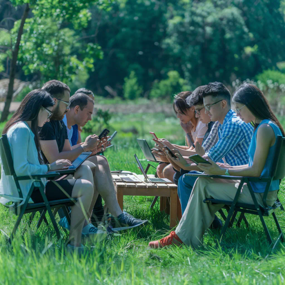 Group of 8 people working digitally in the nature